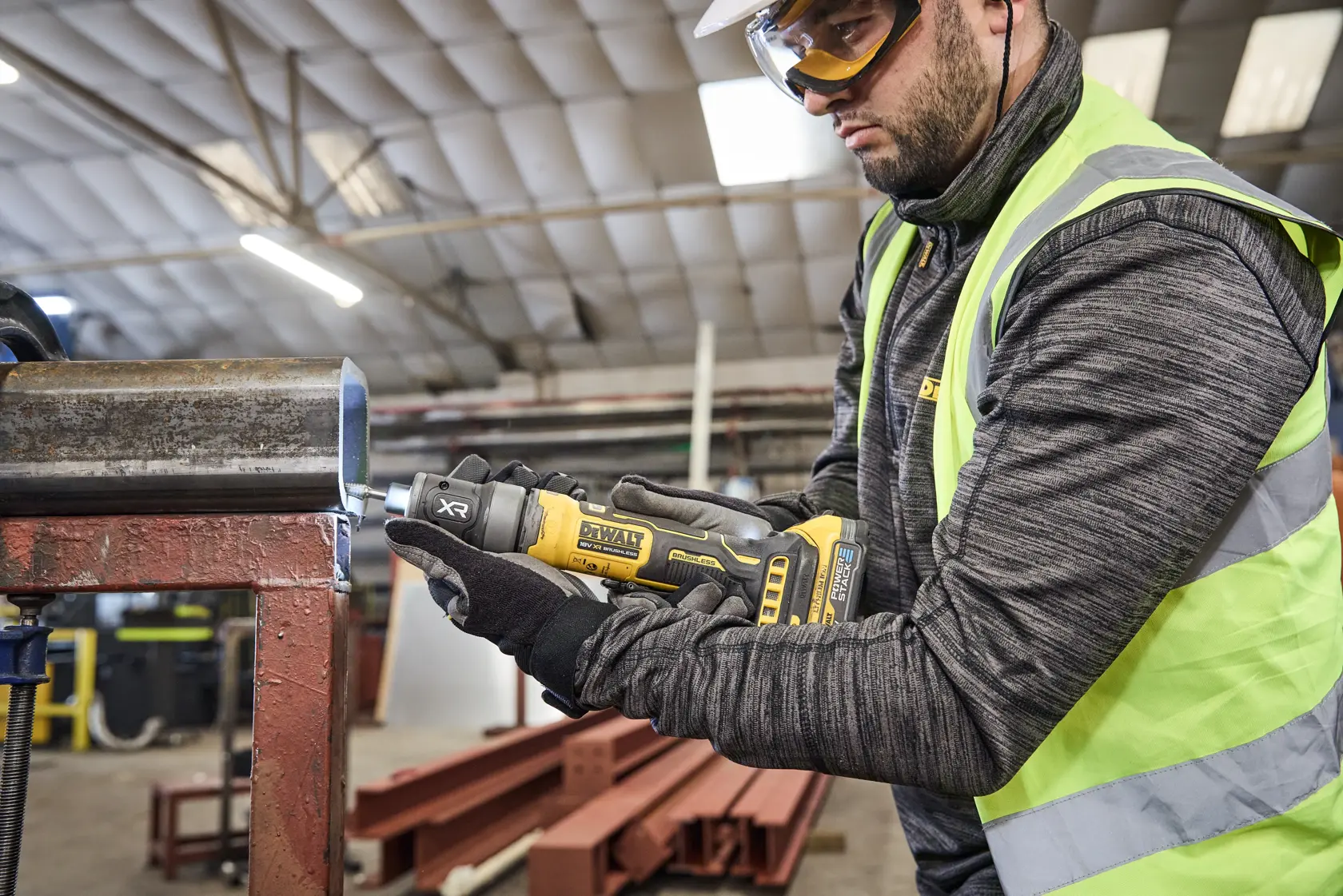 Worker uses DEWALT DCG420N-XJ and DCG420N tool on metal pipe in industrial setting.