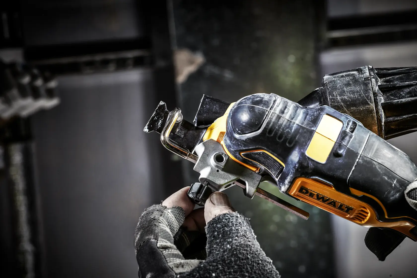 Photo of DEWALT DCS356N oscillating multi-tool in use, black and yellow, worker wearing gloves, close-up.