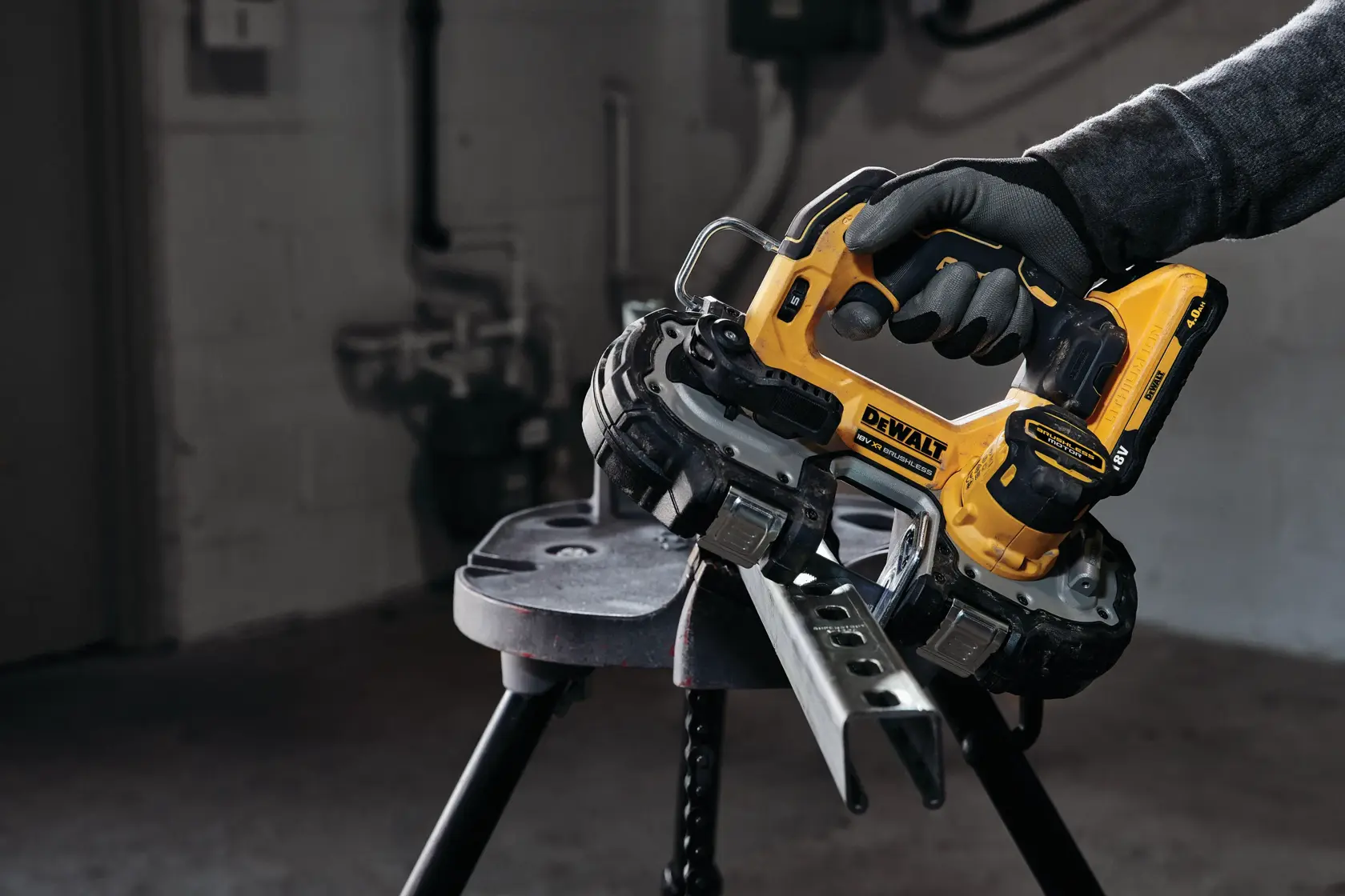 Photo of DEWALT DCS377NT cordless bandsaw cutting metal, held by a gloved hand in an industrial workspace.
