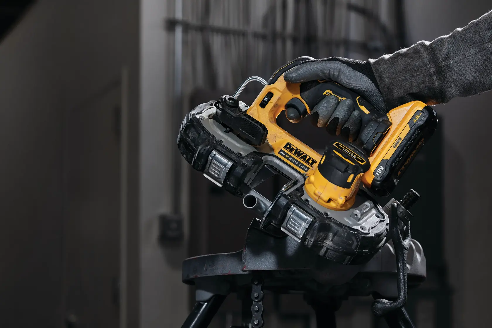 Photo of DEWALT DCS377NT cordless bandsaw in use, yellow and black, cutting metal pipe indoors.