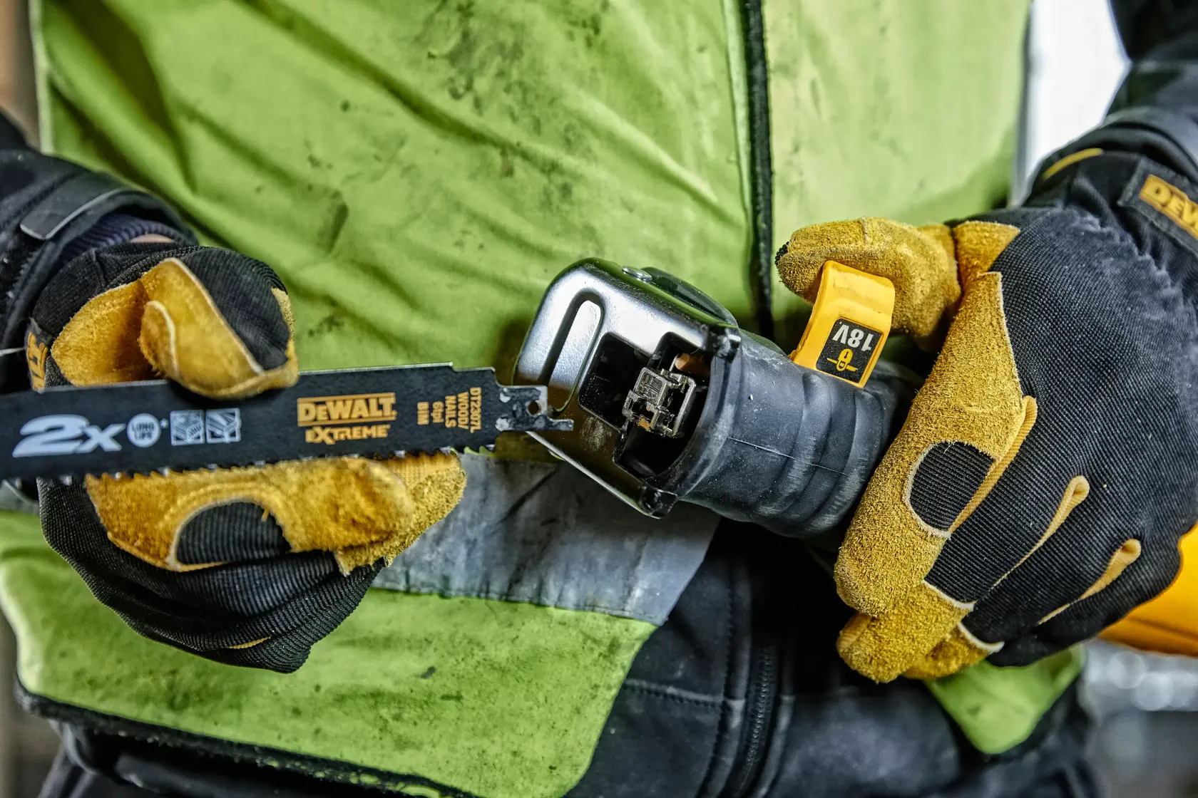 Gloved hands hold a DEWALT reciprocating saw with blade, showing tool details and power specs.