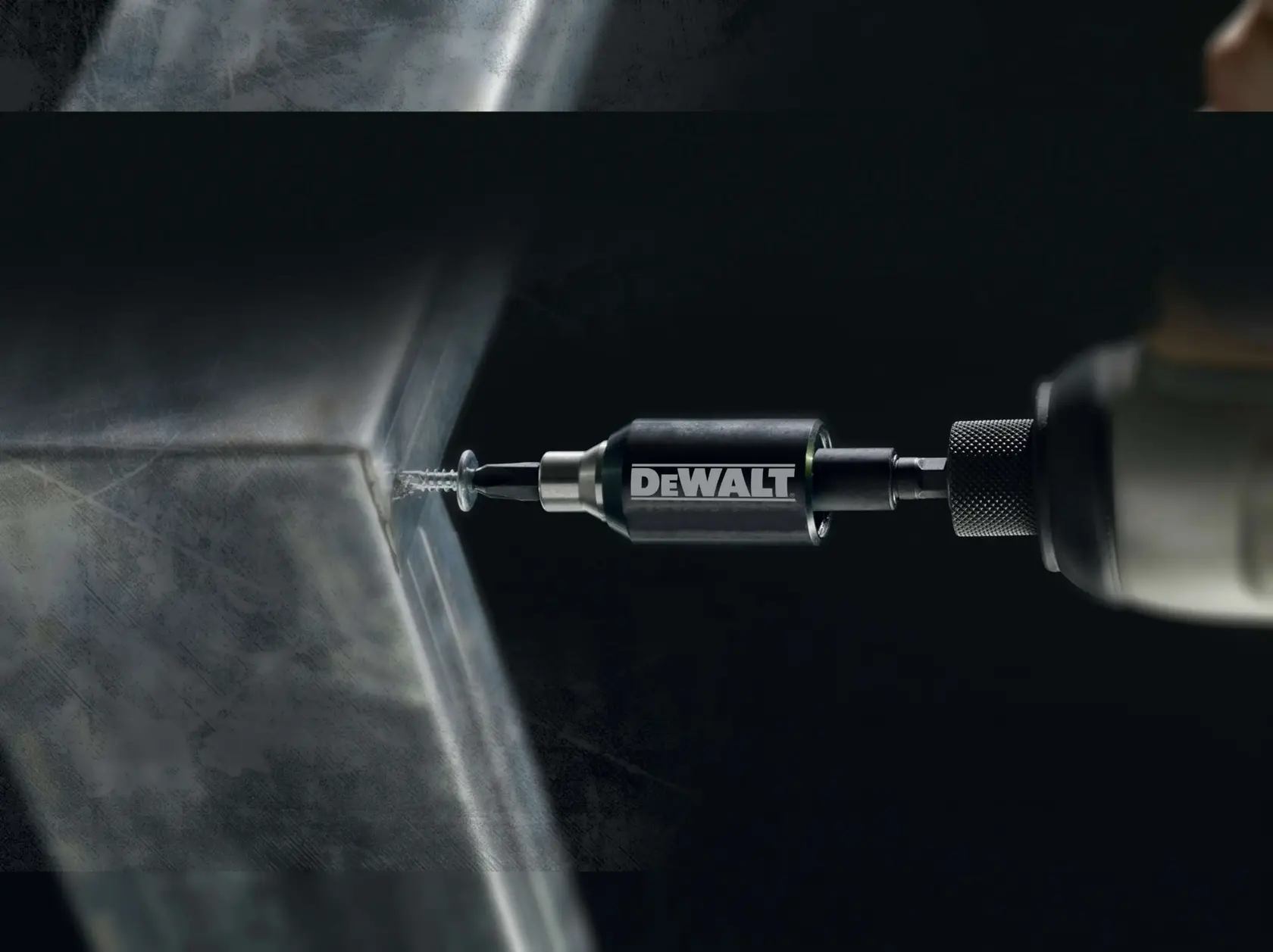 DEWALT DT7513T drill bit driving a screw into metal, close-up view.