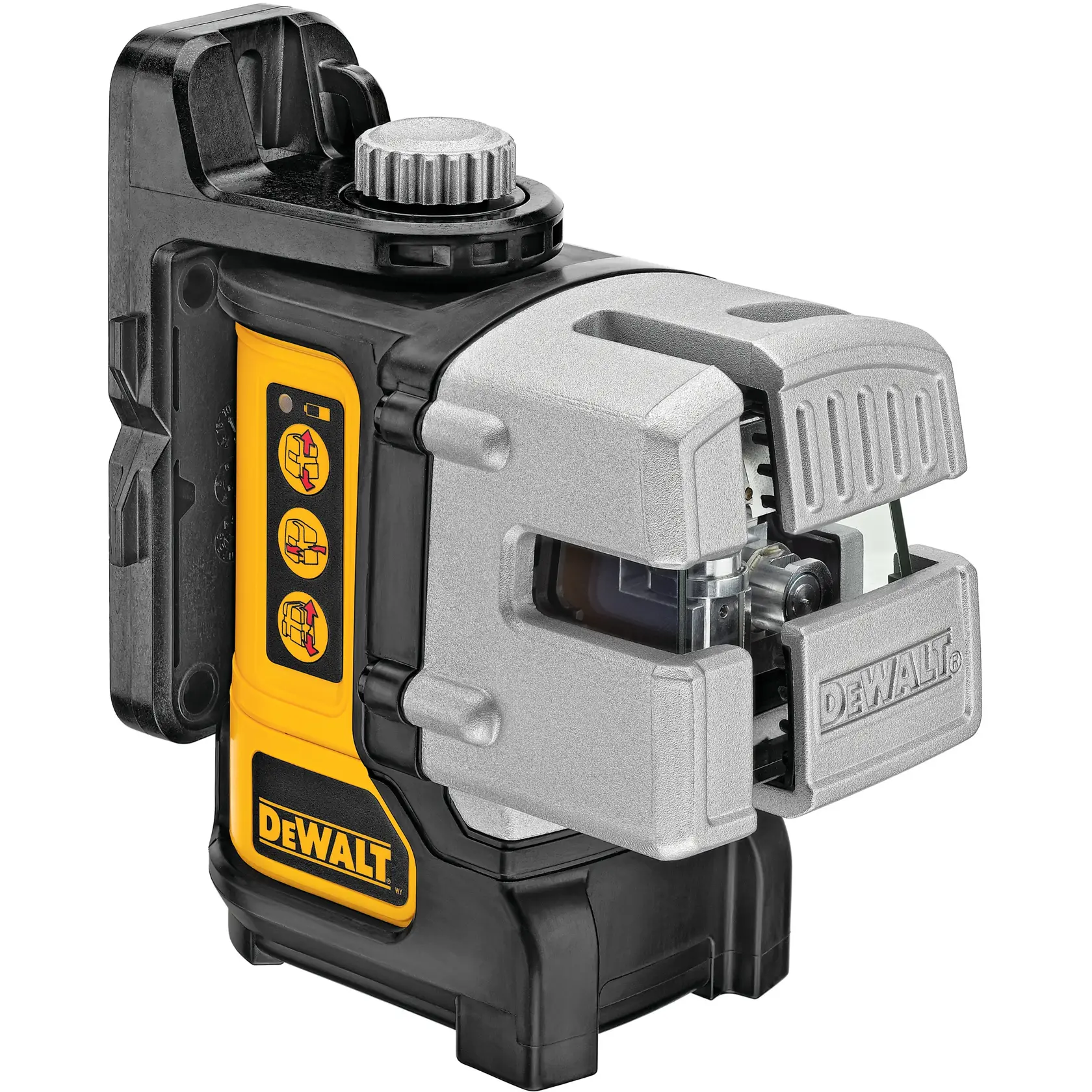A DEWALT DW089K laser level is positioned on the ground at a construction site while a worker wearing a hard hat and tool belt measures with a tape measure on the floor. The background shows various construction equipment, ladders, and exposed ceiling pipes.