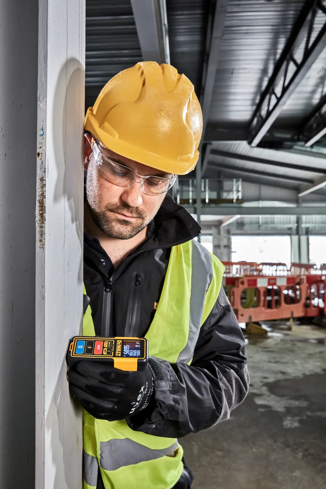 Un télémètre laser DEWALT DW099S avec un boîtier jaune et noir, un écran numérique affichant des mesures et plusieurs boutons incluant unités, arrêt, distance et fonctions Bluetooth.